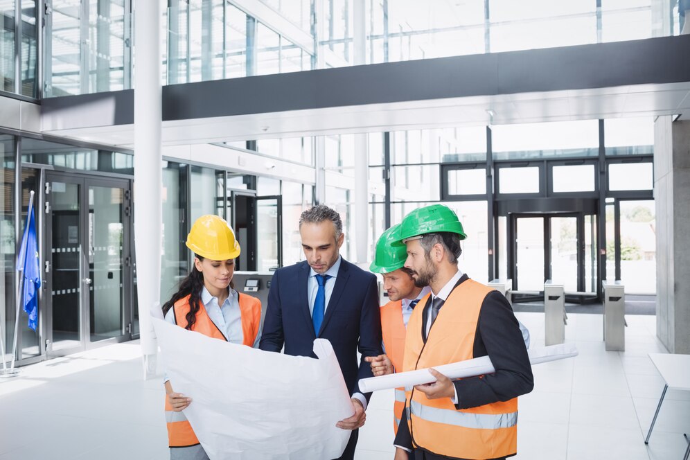businessman-discussing-blueprint-with-architects_107420-74345